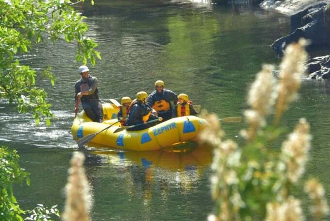 Candid photo of a family rafting on the Merced River